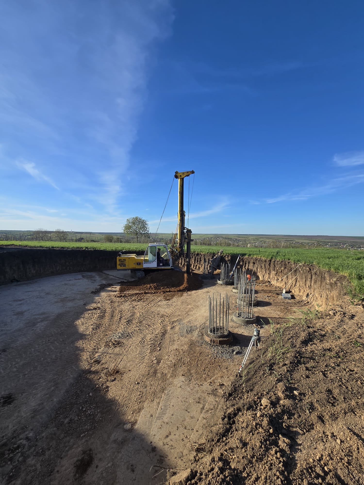Utilajul de foraj și pozițiile piloților, văzute dinspre marginea excavației.
